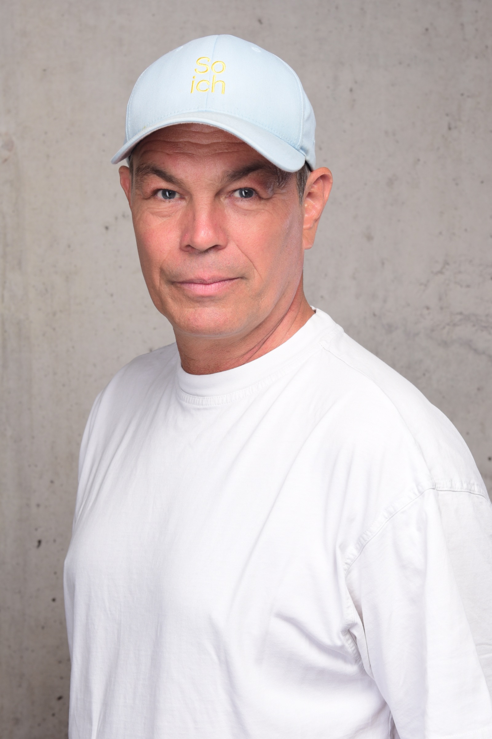 Kim C. Birtel mit „so ich“-Cap vor einer Betonwand