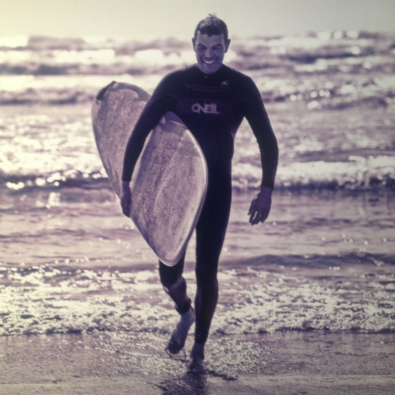 Kim C. Birtel mit Surfboard am Wasser — Surfen als früher Halt in Krisenzeiten